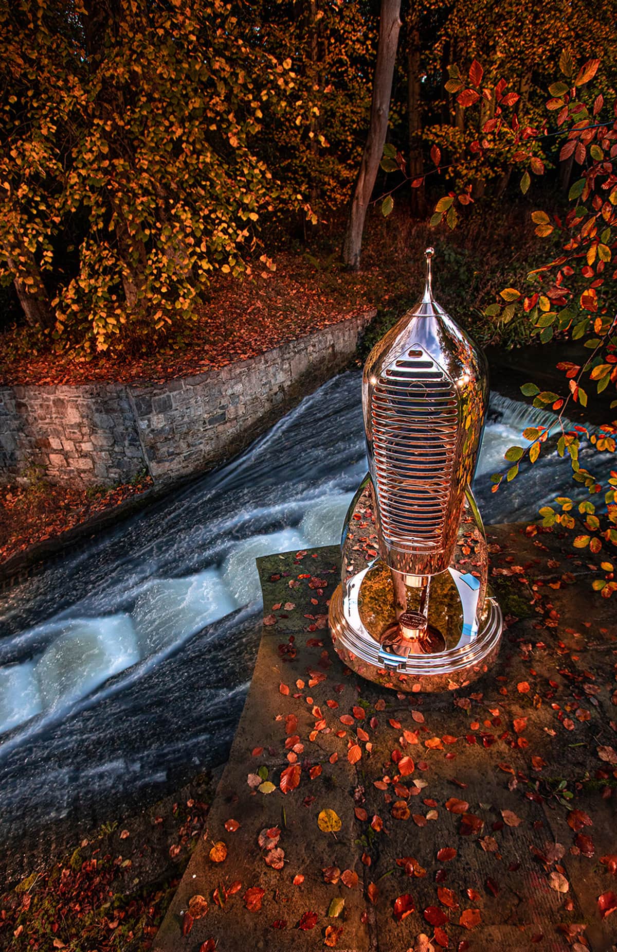 Cosmotron speaker, reflecting the colours of autumn, and a flowing stream,.
