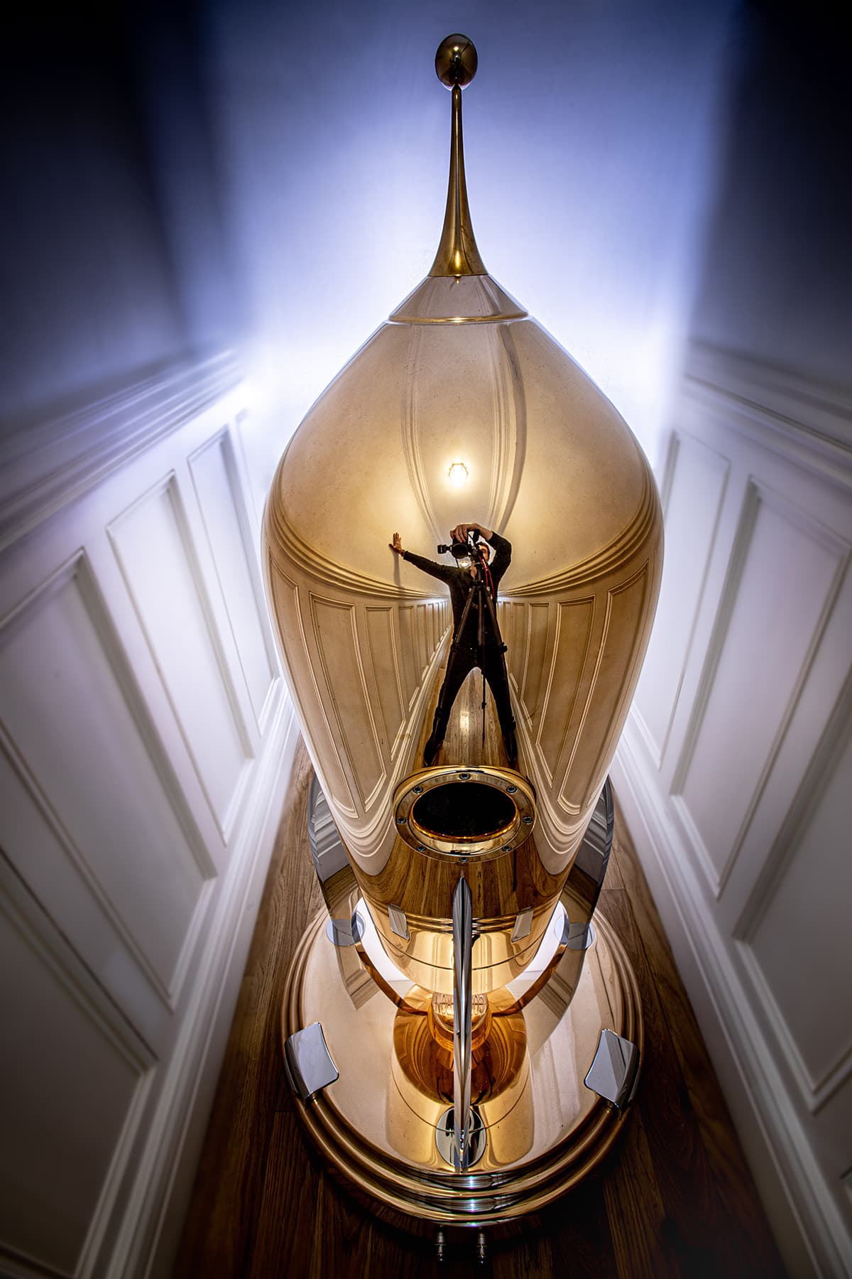 The image of photographer Julian Kronfli reflected in a highly polished bronze Cosmotron 130.